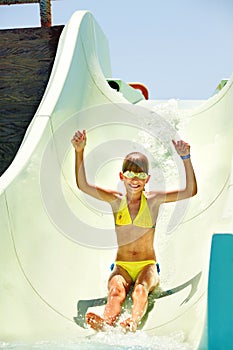 Child on water slide at aquapark.