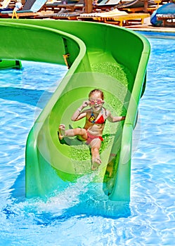 Child on water slide at aquapark.