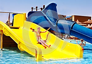 Child on water slide at aquapark.