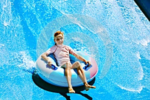 Child on water slide at aquapark.