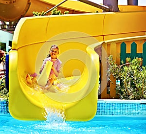 Child on water slide at aquapark.