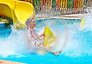 Child on water slide at aquapark.