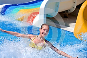 Child on water slide at aquapark.