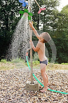 Child in water under garden shower