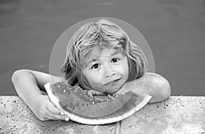 Child with watermelon in pool outdoor. Kid having fun in swimming pool. Kids summer vacation and healthy eating concept.