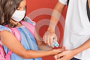 Child wear facemask during coronavirus and flu outbreak.  Apply hand sanitizer