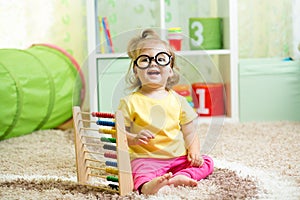 Child weared glasses playing with abacus photo
