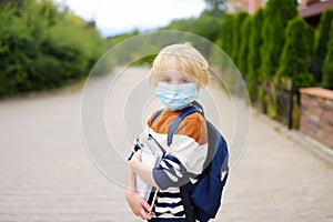 Child wearing face mask going at reopen school after covid-19 quarantine and lockdown. It is new normal for protection and