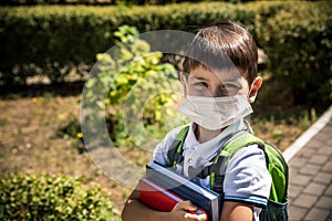 Child wearing face mask going at reopen school after covid-19 quarantine and lockdown. It is new normal for protection and