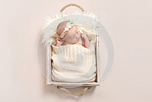 Child wearing a hairband in baby basket, closeup