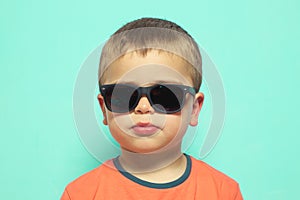 Child wearing sunglasses with a serious attitude