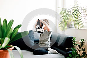 Child wearing virtual reality glasses indoors at home