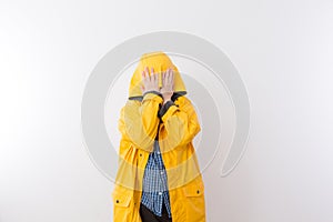 Child Wearing Yellow Rain Coat Hiding Face in Hood photo