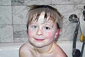 Child with wet hair in the bathtube photo