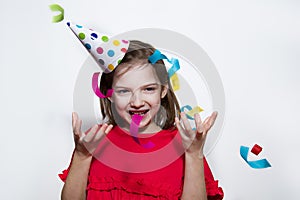 A child on a white background celebrates a bright event, wears a red dress and a cap.