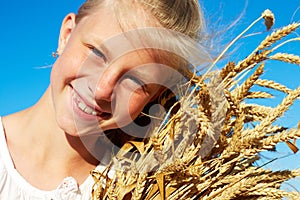 Child in white shirt holding wheat ears in the hands