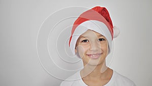 a child in a white T-shirt and a red Santa Claus hat. empty copy space for design or text isolated on white background