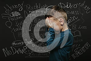 child whose depression is on a black background with his hands closed