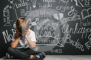 A child whose depression is on a black background with his hands closed