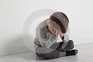 A child whose depression is sitting on the floor