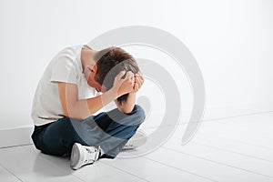 A child whose depression is sitting on the floor