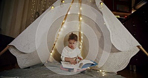 child in a wigwam tent play at night and read a book. happy family kid dream concept. Vercion 3