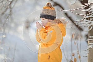 Child winter in in cold weather happy and runs around on snow drifts