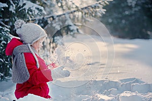 Child in the winter forest. Around the snow and branches of fir