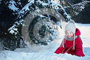 Child in the winter forest. Around the snow and branches of fir