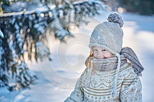 Child in the winter forest. Around the snow and branches of fir