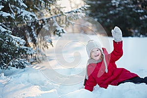 Child in the winter forest. Around the snow and branches of fir