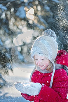 Child in the winter forest. Around the snow and branches of fir