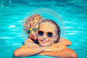 Child and woman playing in swimming pool