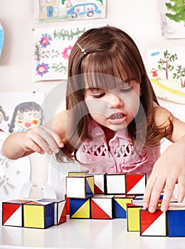 Child with wood block in play room.