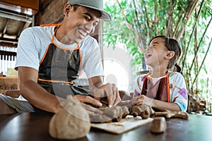 Child working with clay making pottery