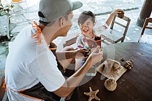 Child working with clay making pottery