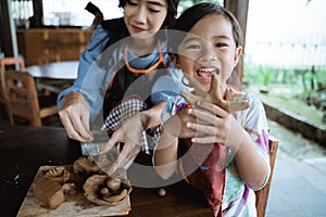 Child working with clay making pottery