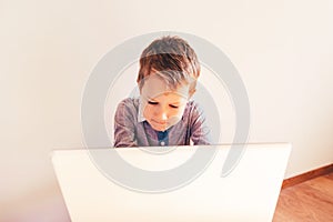 Child working with his computer in his business, concentrated typing to succeed, funny image