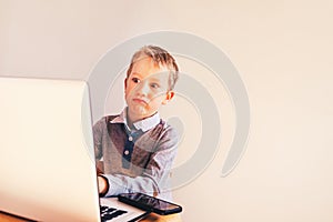 Child working with his computer in his business, concentrated typing to succeed, funny image