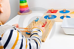 Child works with Montessori material for fine motor skills, sensory play. Playing children photo