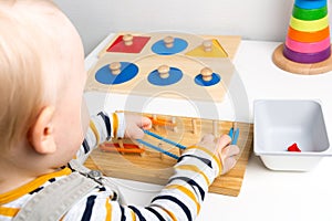 Child works with Montessori material for fine motor skills, sensory play. Playing children photo