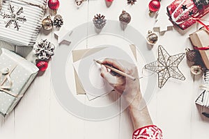 Child writes letter to Santa Claus top view. kid hands holding p