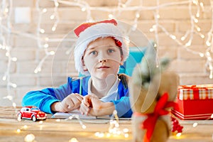 Child writing a letter to Santa Claus at home.