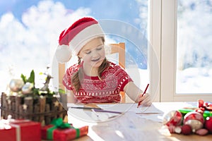 Child writing letter to Santa. Present wish list