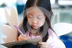 Child Writing on Notebook