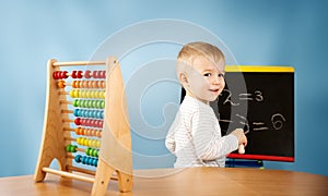 Child writing numbers on chalkboard