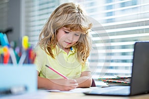 Child writing at school. Cute pupils writing at desk in classroom at the school. Cute boy doing homework, writing and