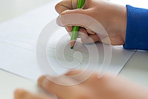 child writing on a sheet of paper.