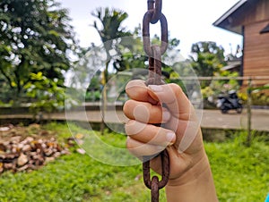 child& x27;s hand holding the iron swing rope. atmosphere on the playground