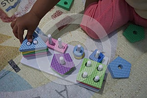 Child& x27;s hand, playing with montessory toys. Geometry puzzle. photo